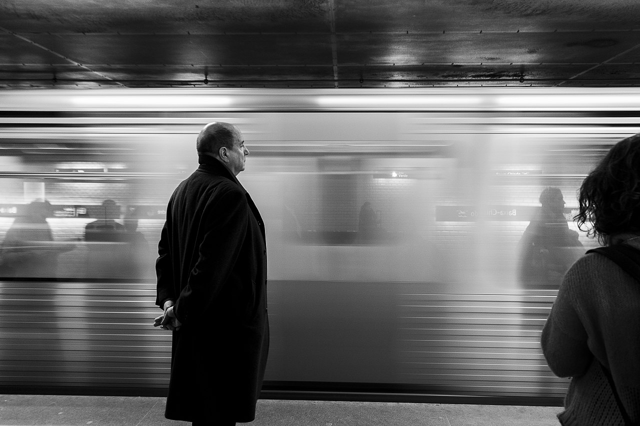 Bald man on subway platform (Unsplash)